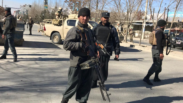 Afghan policemen stand guard at the site of a blast in Kabul 