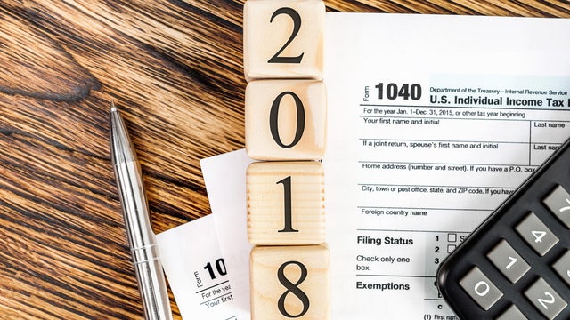 Pay tax in 2018 year concept. Numbers 2018 wit tax form 1040, calculator and pen on the table. Top view. 