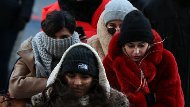 People bundle up against the cold temperature as they walk in Times Square in New York 