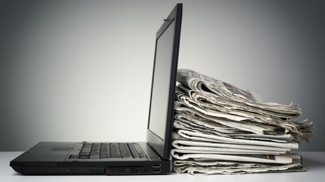 Internet and electronic online news - laptop computer and newspapers generic 