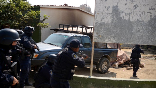 Police officers arrive near where an exchange of gunfire took place between residents and members of a local, self-appointed community police force which according to local media, left 11 dead in La Concepcion 
