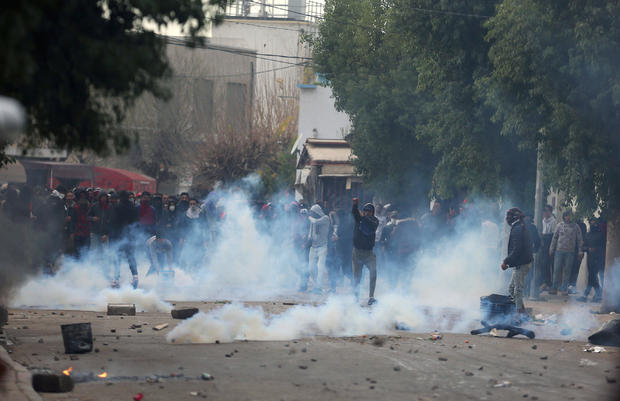 Tear gas is seen as protesters clash with riot police attempting to disperse the crowd during demonstrations against rising prices and tax increases, in Tebourba 