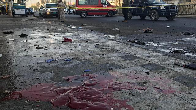 Iraqi security forces inspect the site of a bomb attack in Baghdad 