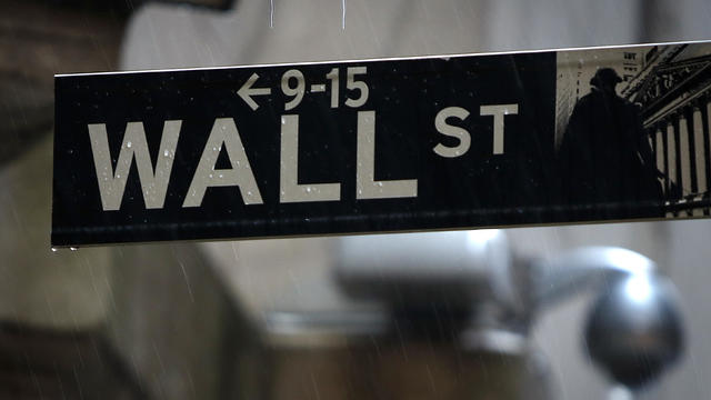 A Wall Street sign is pictured in the rain outside the New York Stock Exchange 