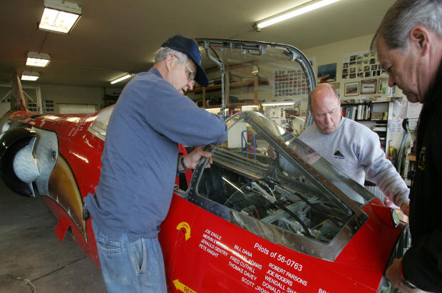 From left, Von Armstrong, Richard Pengelley and Ed Shadle set the windshield down onto the front of the North American Eagle jet-powered vehicle May 3, 2008, in Spanaway, Wash. A handful of Snohomish County residents are part of a team of airplane mechani 