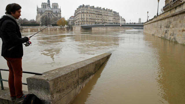 A man fishes on the flooded banks of the River Seine in Paris 