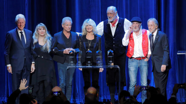 Former U.S. President Bill Clinton (L) and Neil Portnow (R), President & CEO of The Recording Academy, stand with honorees (2nd L-2nd R) Stevie Nicks, Lindsey Buckingham, Christine McVie, Mick Fleetwood, and John McVie during the 2018 MusiCares Person of 