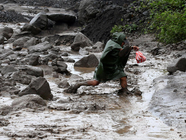 A resident wades through a river with lahar flow coming from Mount Mayon volcano in Guinobatan, Albay province, south of Manila 