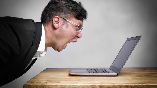 Man screaming at laptop 