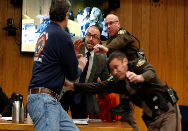 Randall Margraves, left, lunges at Larry Nassar, wearing orange, a former USA Gymnastics team doctor who pleaded guilty in November 2017 to sexual assault charges, during victim statements in his final sentencing hearing in Eaton County Circuit Court in C 