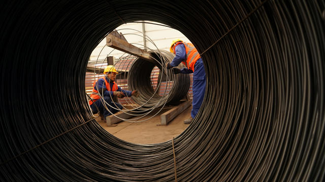 Workers work beside steel wires at a factory in Beijing 