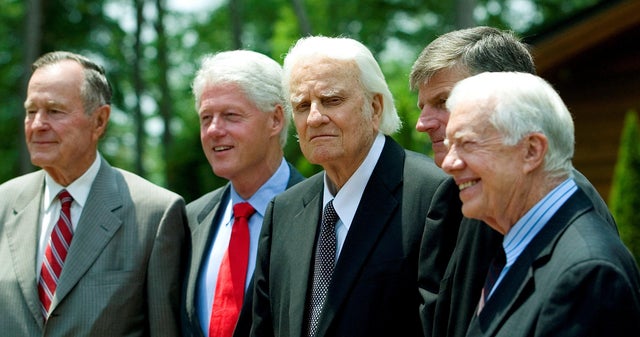 Former Presidents George H.W. Bush, left; Bill Clinton, second left; and Jimmy Carter, right, pose with evangelist Billy Graham and his son Franklin Graham, second right, before the Billy Graham Library dedication on the campus of the Billy Graham Evangel