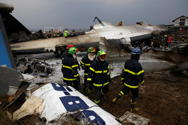 Rescue workers work at the wreckage of a US-Bangla airplane after it crashed at the Tribhuvan International Airport in Kathmandu 