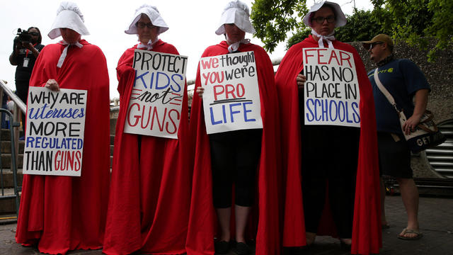 Activists wear red robes and white bonnets based on "The Handmaid's Tale" before the "March for Our Lives", an organized demonstration to end gun violence, in downtown Houston 