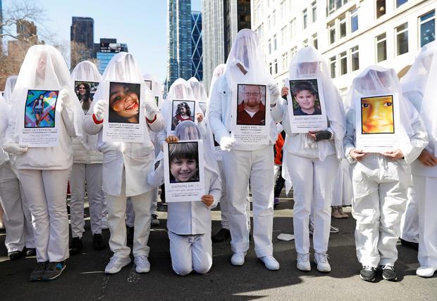 Protesters hold photos of victims of school shootings during a "March For Our Lives" demonstration demanding gun control in New York City 