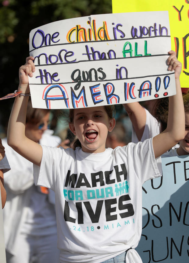 A girl holds a sign while rallying in the street during the "March for Our Lives" demanding stricter gun control laws at the Miami Beach Senior High School, in Miami 
