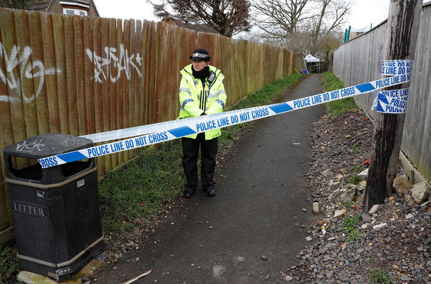 A police officer stands behind cordon tape in an alleyway which has been blocked off near the home of former Russian intelligence officer Sergei Skripal in Salisbury 