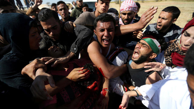 People react as they evacuate Palestinian deaf Tahreer Abu Sabala, 17, who was shot and wounded in the head during clashes with Israeli troops, at Israel-Gaza border, in the southern Gaza Strip 