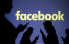 FILE PHOTO: Silhouettes of mobile users are seen next to a screen projection of Facebook logo in this picture illustration 