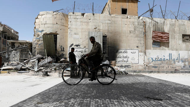 A man rides on a bicycle at the city of Douma in Damascus 