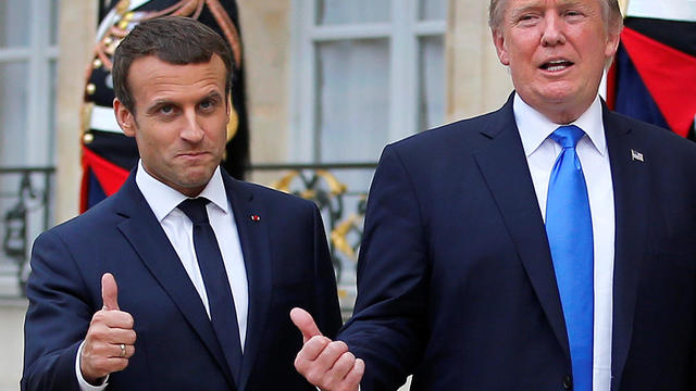 French President Emmanuel Macron and U.S. President Donald Trump react in the courtyard after a joint news conference at the Elysee Palace in Paris 