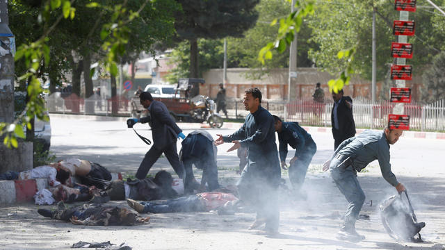 Policemen help Afghan journalists, victims of a second blast, in Kabul 