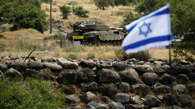 An Israeli tank can be seen near the Israeli side of the border with Syria in the Israeli-occupied Golan Heights 