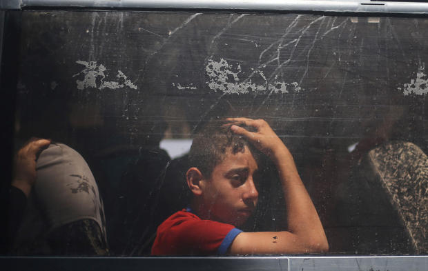 Palestinian boy looks out a bus window as he waits to travel into Egypt through the Rafah border crossing, in the southern Gaza Strip 