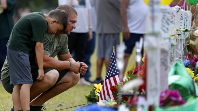 Mourners pray at a makeshift memorial left in memory of the victims killed in a shooting at Santa Fe High School in Santa Fe 