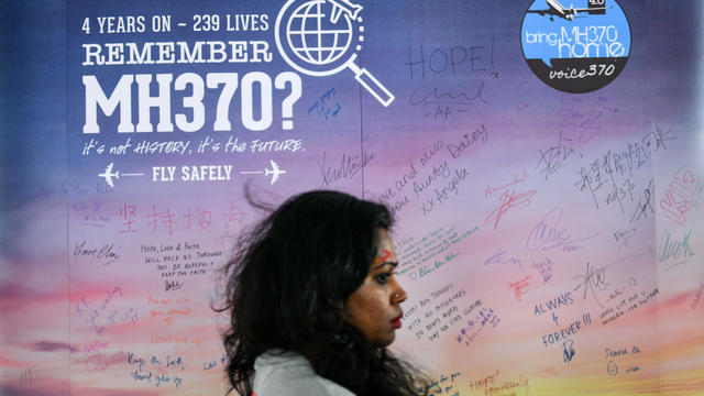 A woman walks past a banner bearing solidarity messages for passengers of the missing Malaysia Airlines Flight 370 during a memorial event in Kuala Lumpur on March 3, 2018, ahead of the fourth anniversary of the ill-fated plane's disappearance. 