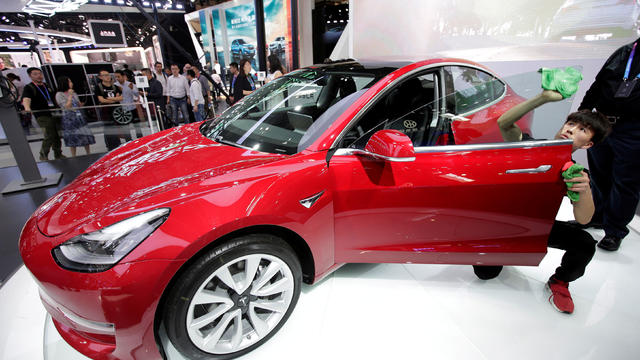 FILE PHOTO: A man cleans a Tesla Model 3 car during a media preview at the Auto China 2018 motor show in Beijing 