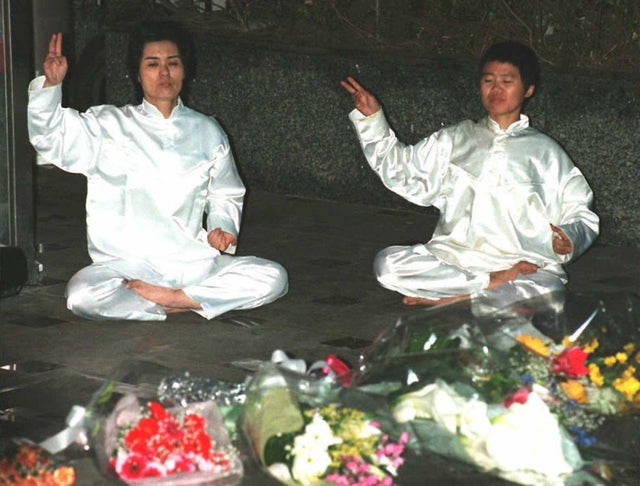Members of the Aum Shinrikyo (Supreme Truth) sit o