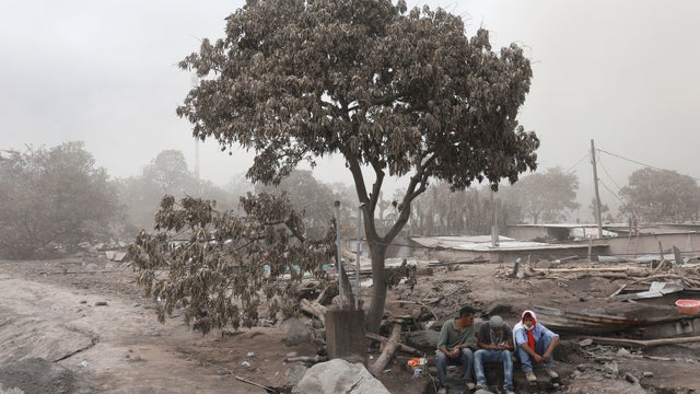 Residents pause during a search at an area affected by the eruption of Fuego volcano in San Miguel Los Lotes in Escuintla 
