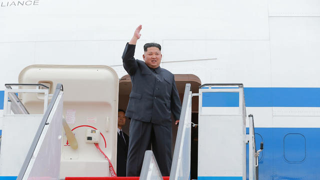 North Korea's leader Kim Jong Un waves before departing Pyongyang to Singapore 