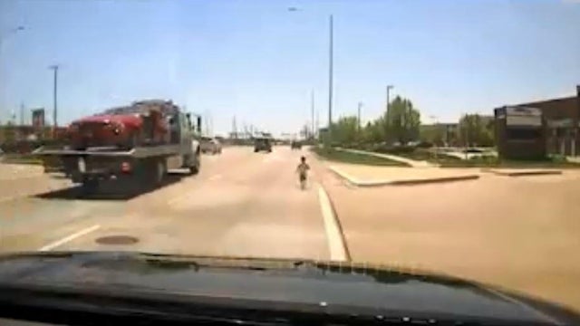 A little boy runs onto a busy highway in Naperville, Illinois, in May 2018 in a screen capture from a video the Naperville Police Department posted to Facebook on June 11, 2018. 