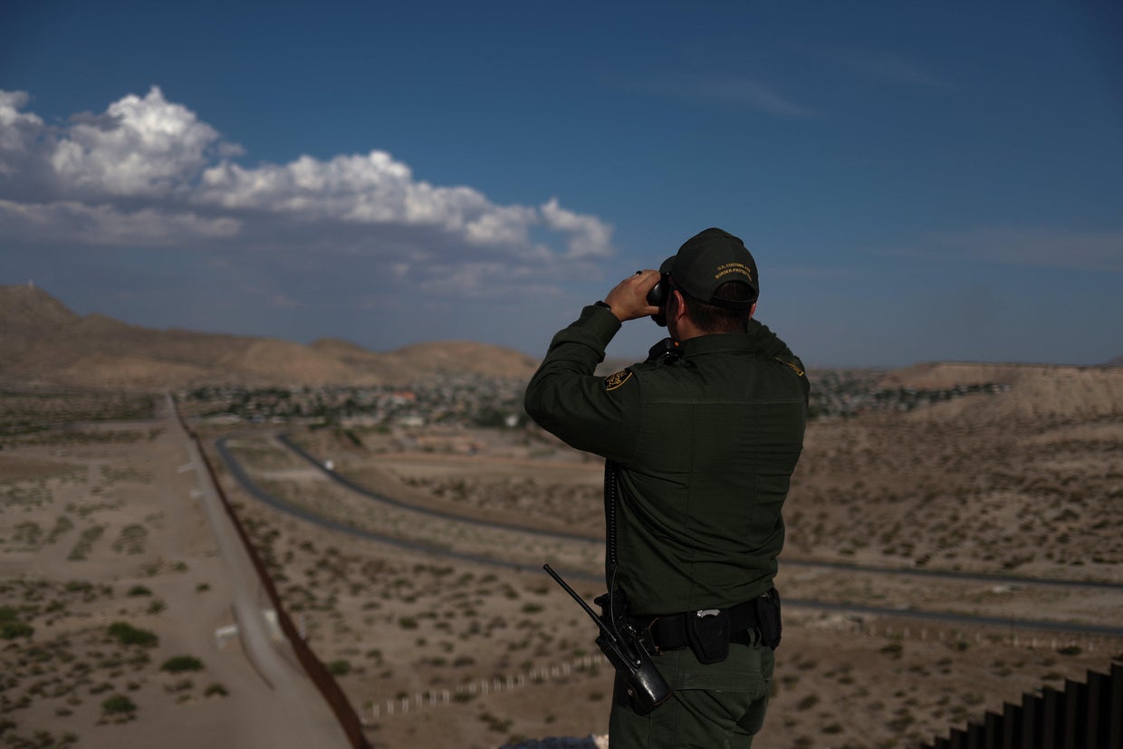 Border patrol agent uses binoculars to search for illegal immigrants along U.S. border with Mexico in Sunland Park, New Mexico, 