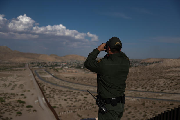 Border patrol agent uses binoculars to search for illegal immigrants along U.S. border with Mexico in Sunland Park, New Mexico, 