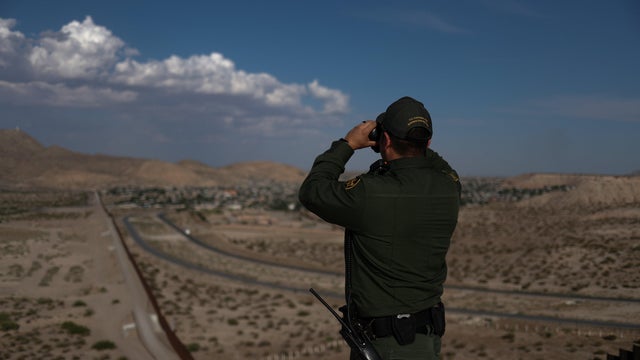 Border patrol agent uses binoculars to search for illegal immigrants along U.S. border with Mexico in Sunland Park, New Mexico, 