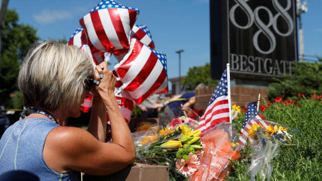 Kim Wither says a prayer at an impromptu memorial outside of The Capital Gazette the day after a gunman killed five people inside the newspaper's building in Annapolis, Maryland, June 29, 2018. 