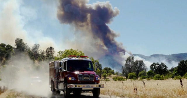 Heat, high winds fuel more than 2 dozen wildfires in the West - CBS News