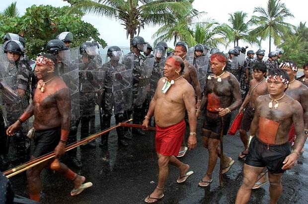 Indigenous members of the Yanomami tribe pass mili 