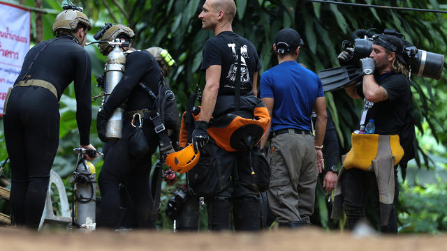 International divers carry equipments as they prepare to go in to Tham Luang cave complex, as members of an under-16 soccer team and their coach have been found alive according to local media in the northern province of Chiang Rai 
