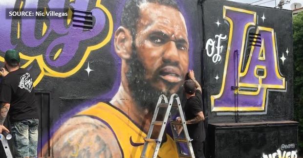 Artists Jonah Never and Menso repairing defaced LeBron James mural, July 8, 2018. (SOURCE: Nic Villegas) 
