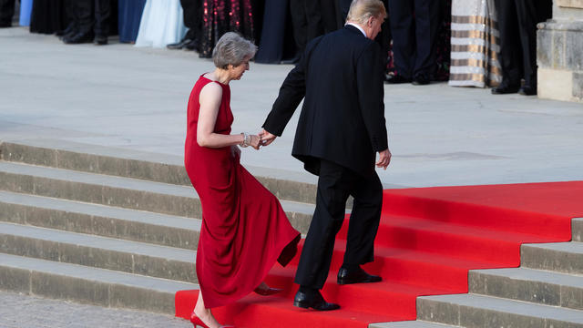 U.S. President Donald Trump leads British Prime Minister Theresa May by the hand as they climb the steps to the entrance of Blenheim Palace, where they are attending a dinner with other specially invited guests and business leaders, near Oxford 