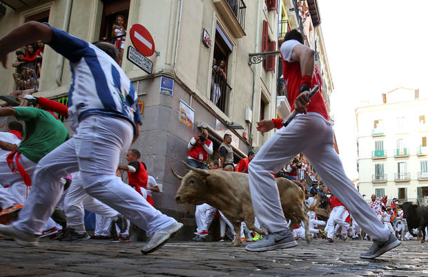 Revellers sprint in front of bulls during the fifth running of the bulls of the San Fermin festival in Pamplona 