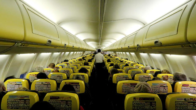 FILE PHOTO: A cabin crew member serves passengers onboard a Ryanair passenger aircraft travelling from Madrid International Airport to Bergamo Airport 