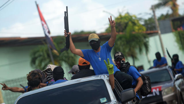 Paramilitary fighters flash the "V" sign from a truck in the Monimbo neighborhood in Masaya, Nicaragua, on July 18, 2018, following clashes with anti-government demonstrators. 