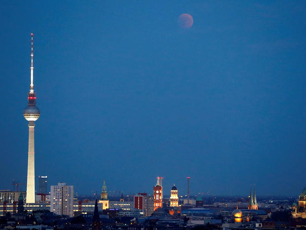 Lunar eclipse is seen above the cityscape and the television tower in Berlin 