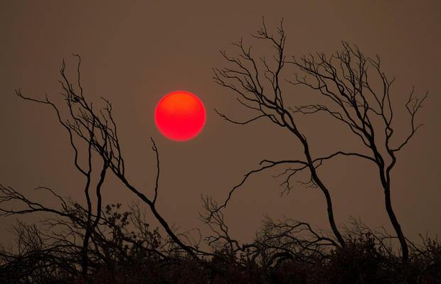 The suns sets over hills burned by the Carr Fire west of Redding 