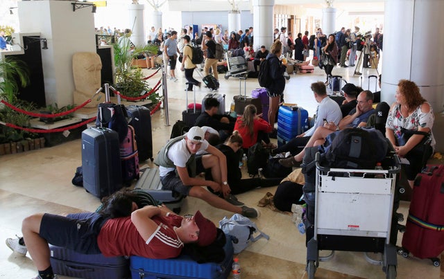 Foreign tourists sit and lie on the floor as they queue to leave Lombok Island after an earthquake hit, as seen at Lombok International Airport, Indonesia